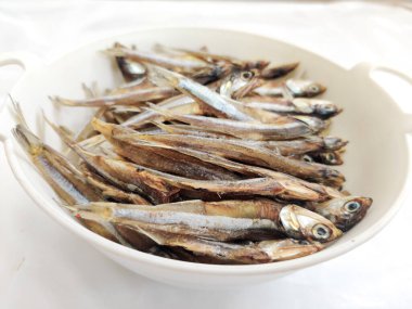 Kurutulmuş Ançüez Balığı, otlar ve limonlarla süslenmiş Beyaz Arka plan, Seçici Odak.