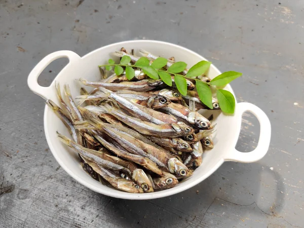 Dried Anchovy Fish decorated with herbs and lemons on a floor Background,Selective Focus.