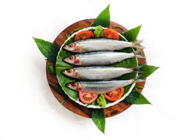 Taze Slender Gökkuşağı Sardalyası ahşap bir asma üzerinde sebze ve otlarla süslenmiş..