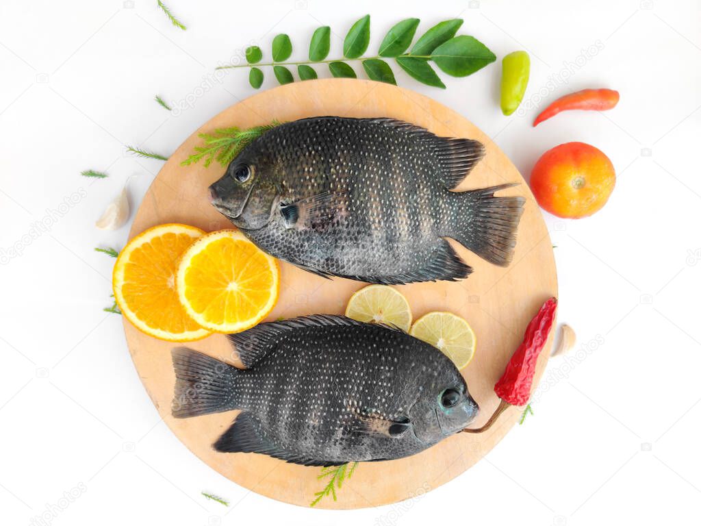 pearl spot fish /Karimeen decorated with herbs and fruits. isolated on white Background.Selective focus.