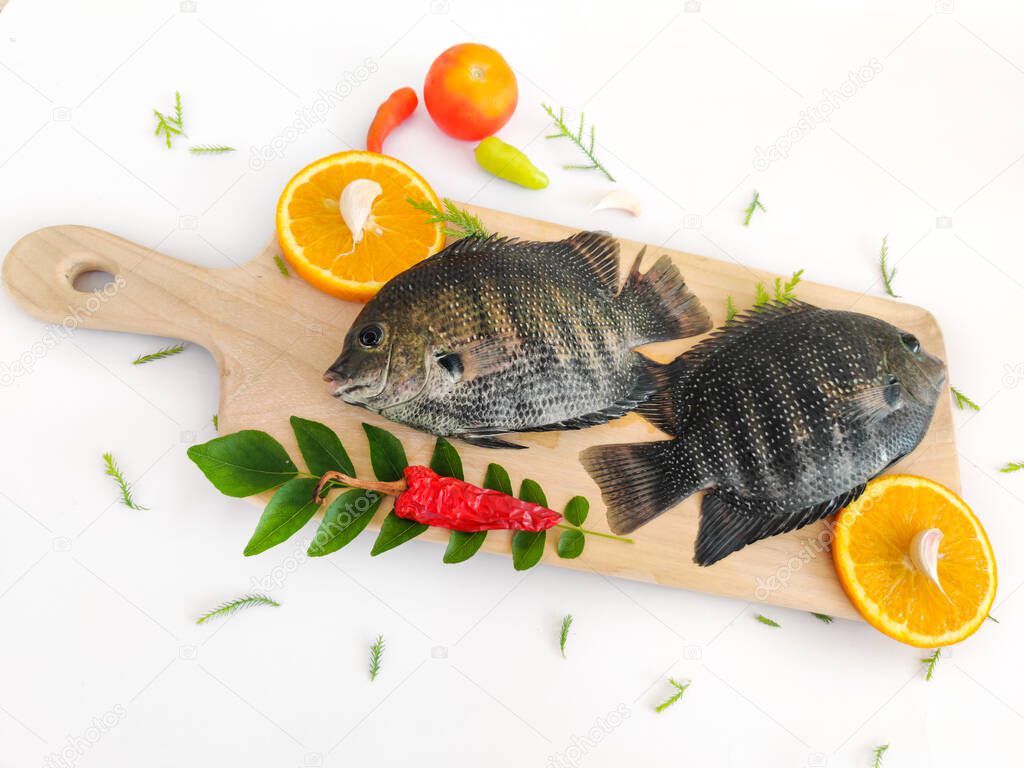 pearl spot fish /Karimeen decorated with herbs and fruits. isolated on white Background.Selective focus.