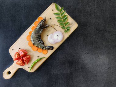 Taze Dev Kaplan Karidesi otlar ve sebzelerle süslenmiş ahşap bir asma üzerinde. Metin için boşluk..