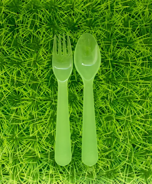 Yeşil kaşık ve çatal yeşil çim üzerinde