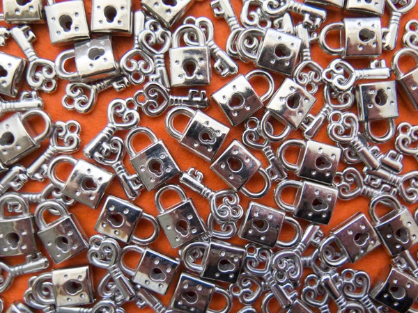 Lots of little lock-and-key on orange background — Stock Photo, Image