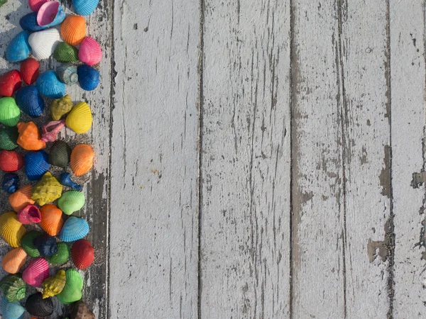 Mesa blanca de madera con conchas de colores —  Fotos de Stock