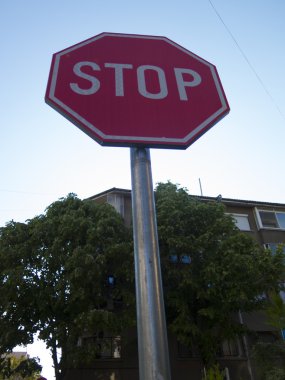 Yol işaret Stop, mavi gökyüzü, ağaçlar ve evler