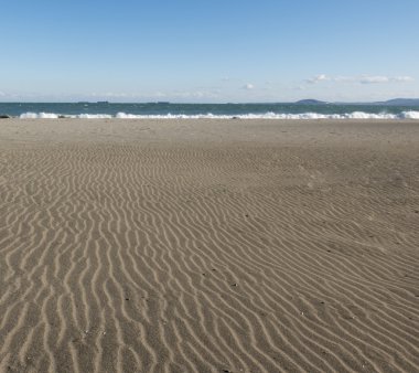 Kum ve deniz dalgaları.