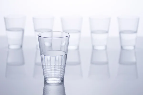 Water filled glasses over white background