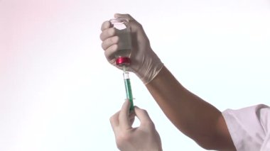 Doktor elinde şırınga tutuyor.