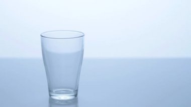 Mavi arka planda bir bardak su