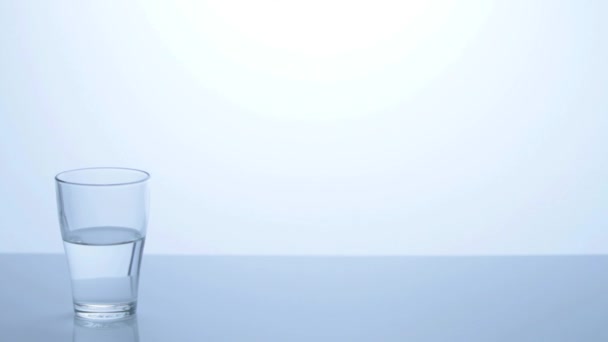 Medio vaso lleno de agua — Vídeos de Stock