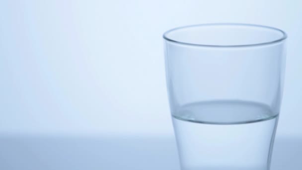 Medio vaso lleno de agua — Vídeo de stock