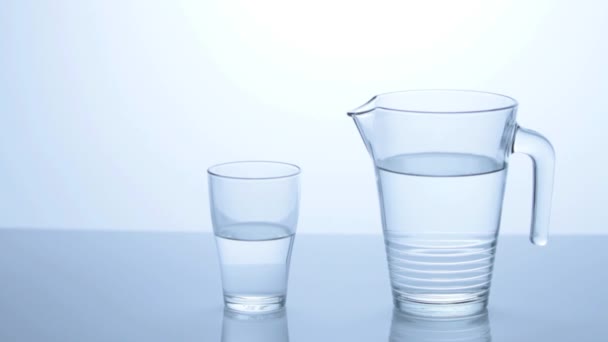 Eau coulant d'un pichet dans un verre 