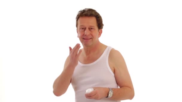 Mann ölt sein Gesicht mit Lotion — Stockvideo