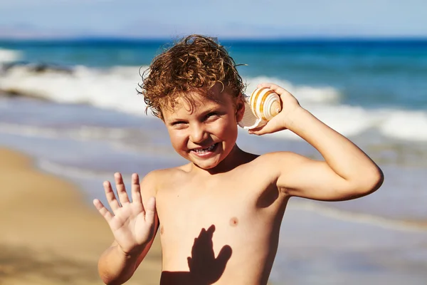 Chico escuchando shell — Foto de Stock