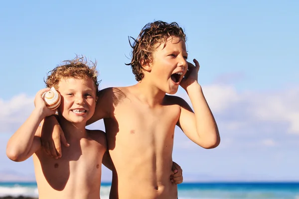 Jungen hören Muscheln zu — Stockfoto