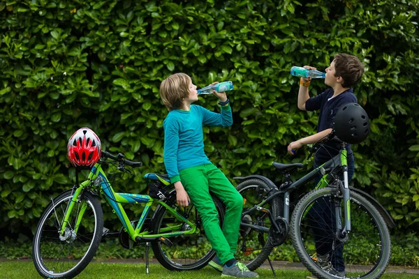 Two boys in a garden with bikes — Stock Photo, Image