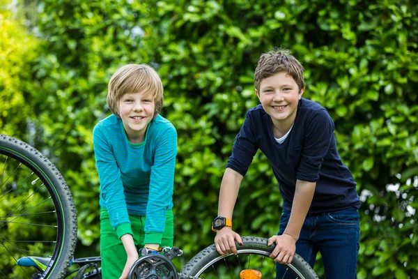 Два мальчика ремонтируют велосипед — стоковое фото
