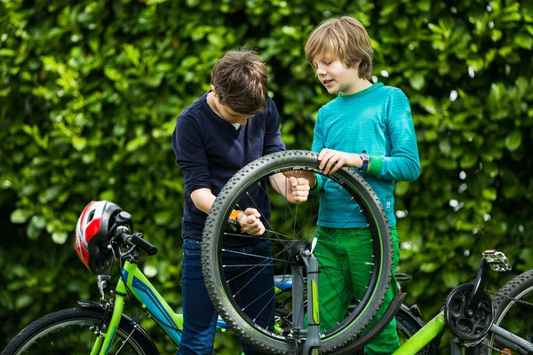 Twee jongens een fiets repareren Rechtenvrije Stockfoto's