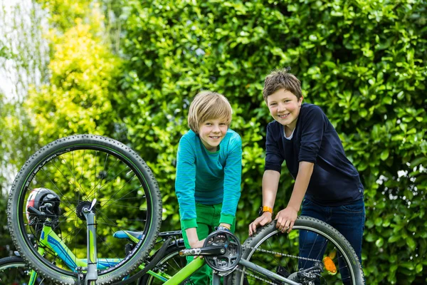 Twee jongens een fiets repareren Stockafbeelding