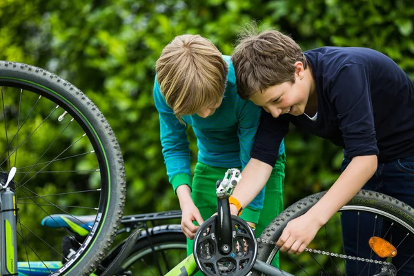 Twee jongens een fiets repareren Stockfoto