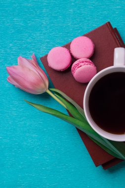Pembe Lale, bir fincan kahve, kitaplar ve üç pembe macaroons