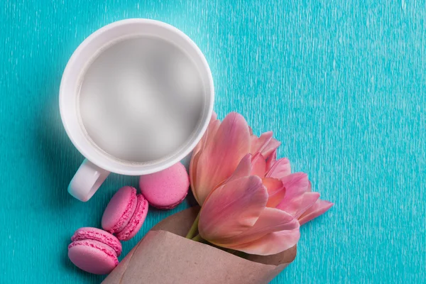 Três tulipas rosa, uma xícara de café e três macaroons rosa — Fotografia de Stock