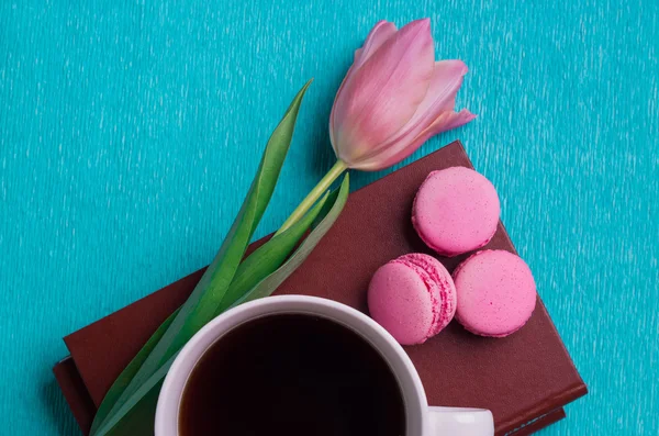 Pink tulip, a cup of coffee, books and three pink macaroons — Stock Photo, Image