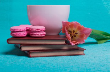 Pembe Lale, bir fincan kahve, kitaplar ve üç pembe macaroons