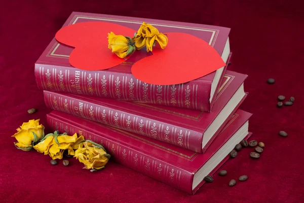 Two hearts lying on the books with roses and coffee beans — Stock Photo, Image