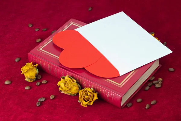 Two hearts in the envelope lying on the book with roses — Stock Photo, Image