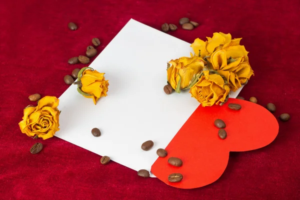 Červené srdce v obálce se sušenými růžemi a kávová zrna — Stock fotografie