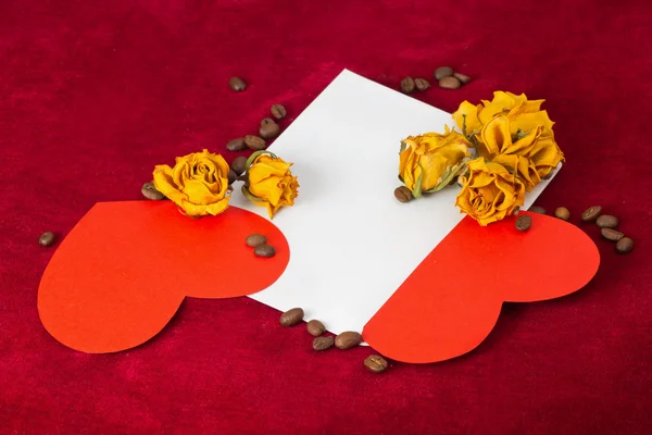 Zwei rote Herzen im Umschlag mit getrockneten Rosen und Kaffeebohnen — Stockfoto