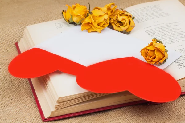 Dos corazones en el sobre con rosas secas acostadas en el libro — Foto de Stock