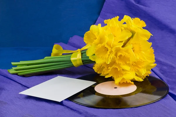 Flores de narciso, envelope no fundo com registro de vinil — Fotografia de Stock