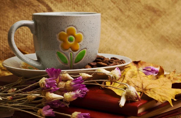 The cup of coffee lying on the books with maple leaves — Stock Photo, Image