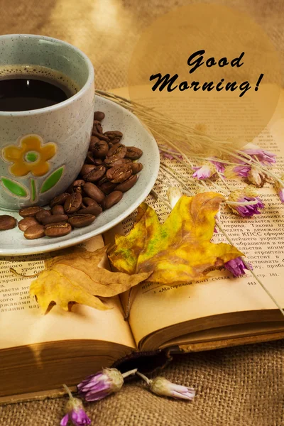 The cup of coffee lying ot the opened book with maple leaves — Stock Photo, Image