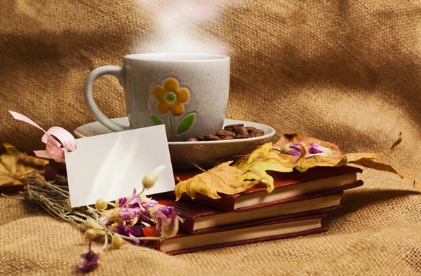 La taza de café que yace en los libros con hojas de arce Imagen De Stock
