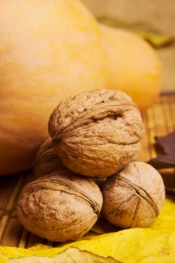 Rustik arka plan ile akçaağaç yaprakları, ceviz ve kabak