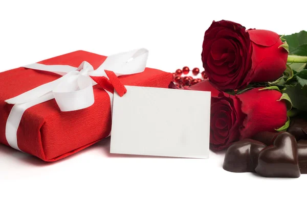 Coffret cadeau rouge avec ruban, roses rouges, carte postale et bonbons — Photo