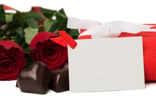 Coffret cadeau rouge avec ruban, roses rouges, carte postale et bonbons — Photo