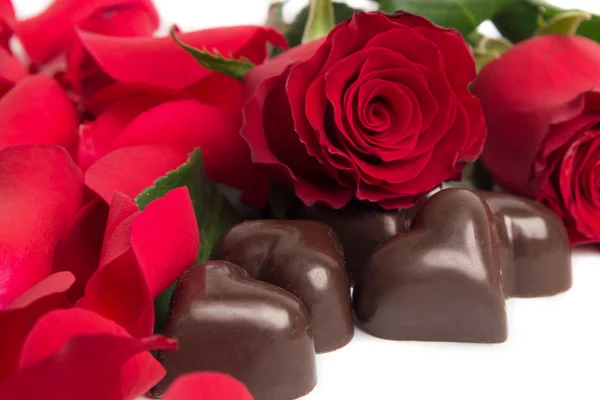 Röda rosor, röda rosenblad och godis — Stockfoto
