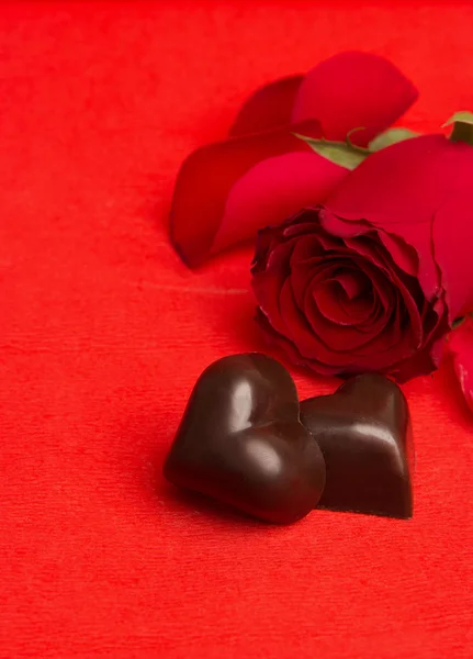 Red roses and candies in a shape of a heart — Stock Photo, Image