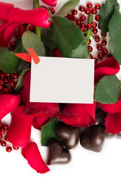 Rote Rosenblätter, rote Rosen und Bonbons in Herzform — Stockfoto