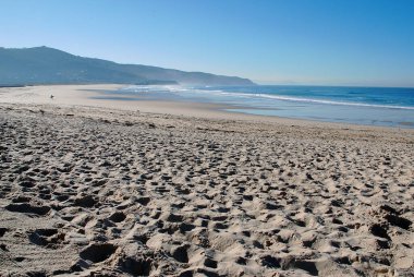 Temiz kum ve mavi denizi olan güzel bir sahilde