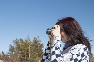 Kızıl saçlı kadın eski bir kamera ile