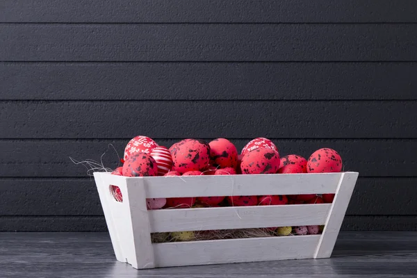 Ovos de Páscoa vermelhos em um recipiente de madeira — Fotografia de Stock