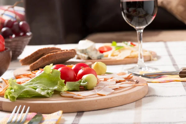 Homemade dinner with bread, tomatoes, cheese, ham and wine — Stock Photo, Image