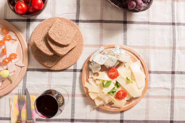 Homemade dinner with bread, tomatoes, cheese, ham and wine — Stock Photo, Image