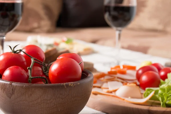 Homemade dinner with bread, tomatoes, cheese, ham and wine — Stock Photo, Image